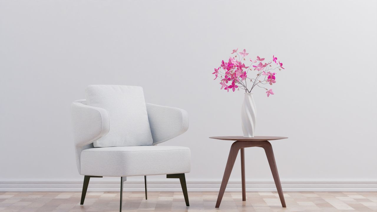 Vase blanc sculptural avec orchidées roses sur une table en bois, dans un intérieur contemporain NATURA