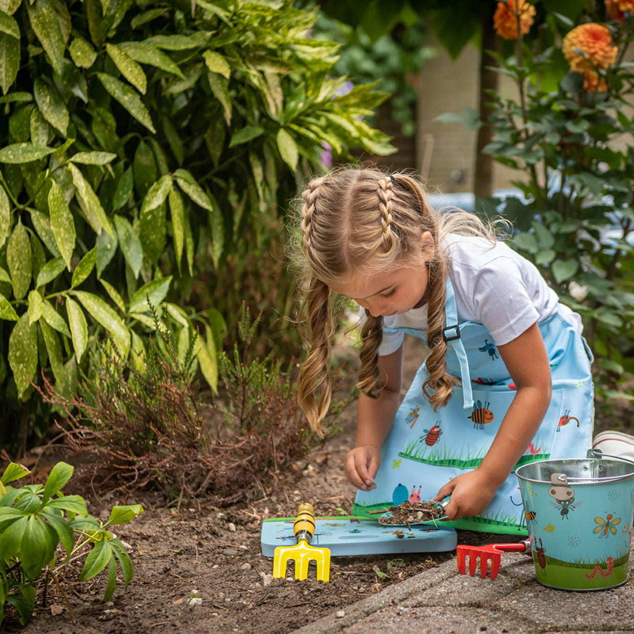 
                  
                    petite fille qui jardine avec ses outils adaptés pour enfants
                  
                